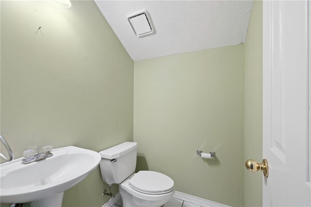 116 Fay Way, Slidell, LA 70460 - half bathroom featuring a sink, lofted ceiling, toilet, baseboards, and a textured ceiling