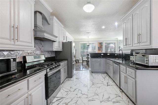 1332 Denmark Ct, Slidell, LA 70461 - kitchen featuring appliances with stainless steel finishes, light marble finish floors, a textured ceiling, a sink, and backsplash
