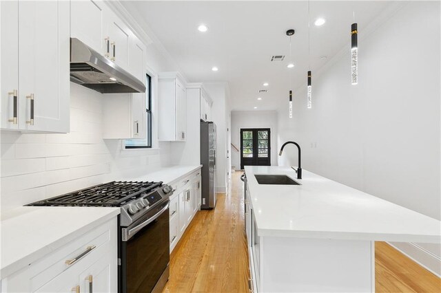 172224 St Ann St, New Orleans, LA 70116 - kitchen with stainless steel appliances, under cabinet range hood, a sink, a center island with sink, and light wood-style flooring