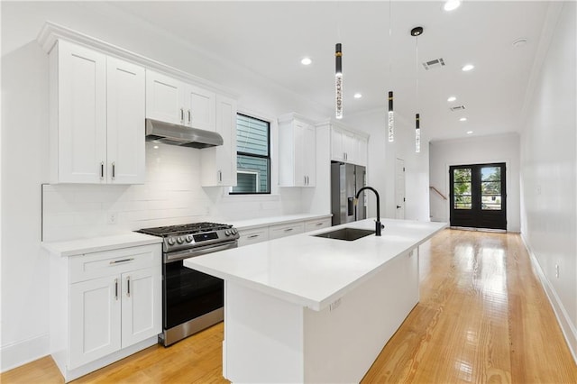 172224 St Ann St, New Orleans, LA 70116 - kitchen featuring stainless steel appliances, a sink, under cabinet range hood, an island with sink, and backsplash
