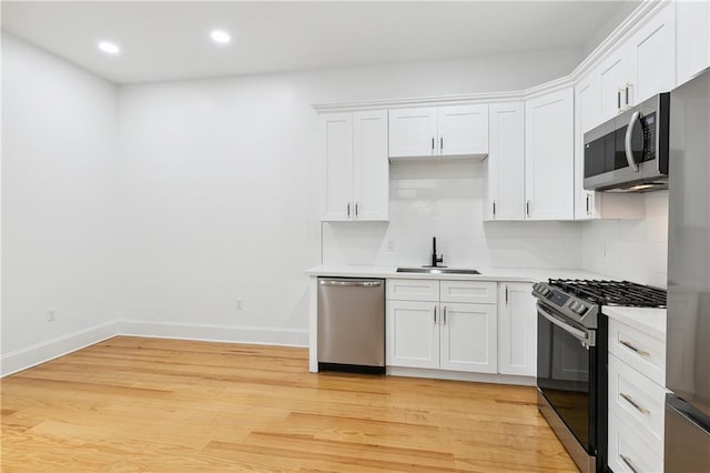 172224 St Ann St, New Orleans, LA 70116 - kitchen with stainless steel appliances, a sink, light countertops, white cabinetry, and recessed lighting