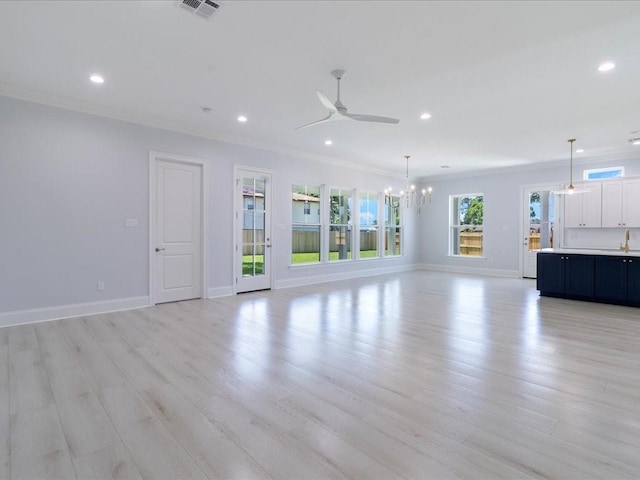 unfurnished living room with a ceiling fan, recessed lighting, crown molding, a chandelier, and baseboards