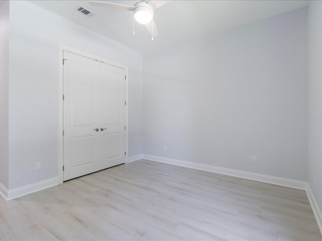 unfurnished bedroom featuring light wood-type flooring, baseboards, a closet, and a ceiling fan