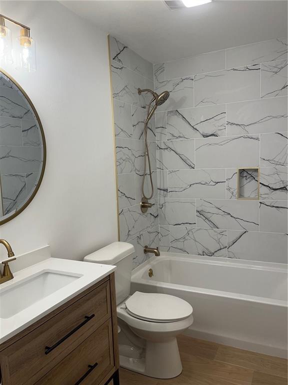 1819 Baronne St, New Orleans, LA 70113 - full bath with tub / shower combination, vanity, toilet, and wood finished floors