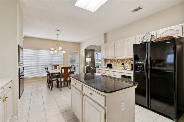 3 Lake Lynn Dr, Harvey, LA 70058 - kitchen with black appliances, arched walkways, a center island, a chandelier, and light tile patterned flooring