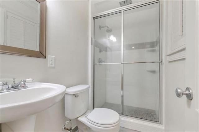 726 S Massachusetts St, Covington, LA 70433 - bathroom featuring toilet, a shower stall, and a sink