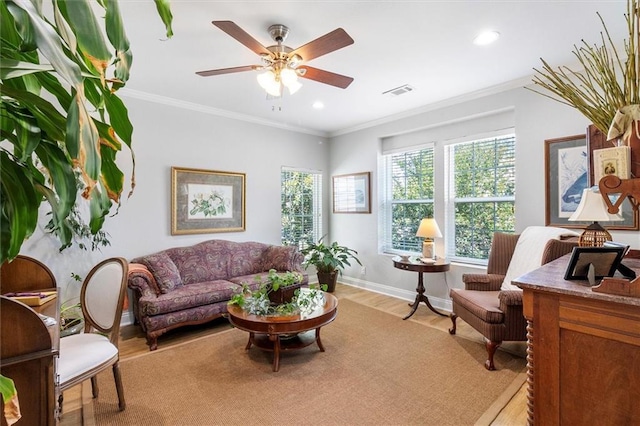 living area featuring light wood-style floors, a ceiling fan, baseboards, recessed lighting, and crown molding