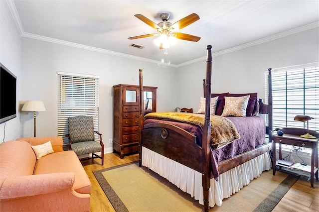 bedroom with light wood finished floors, crown molding, ceiling fan, and baseboards