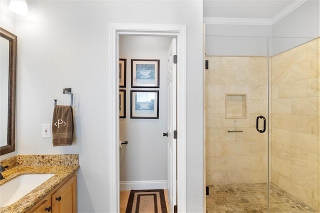 bathroom with a shower stall, vanity, baseboards, and ornamental molding