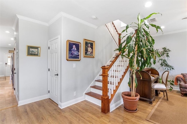 stairway featuring crown molding, baseboards, wood finished floors, and recessed lighting