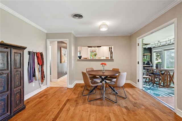 5139 Pratt Dr, New Orleans, LA 70122 - dining area with light wood finished floors, ornamental molding, and baseboards