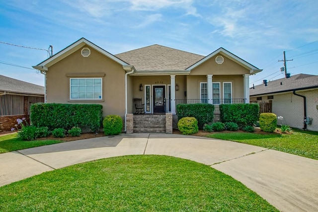 view of front of home featuring a front lawn, covered porch, and stucco siding