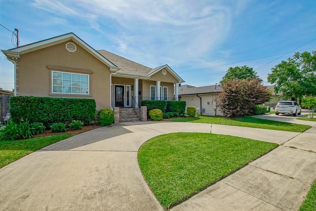 view of front of house with a front yard, stucco siding, curved driveway, and a porch