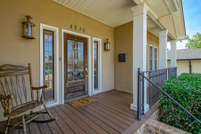 doorway to property featuring stucco siding and covered porch