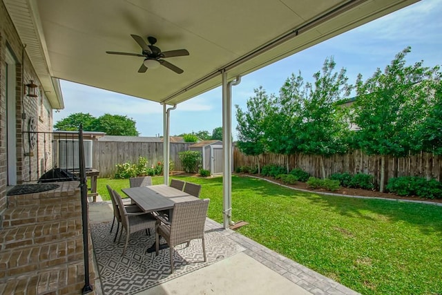 view of patio / terrace with a shed, a ceiling fan, outdoor dining area, and an outdoor structure