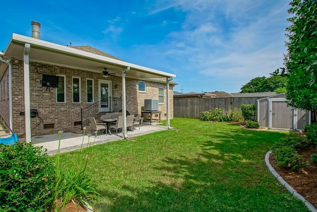 rear view of property with a shed, ceiling fan, a patio, an outbuilding, and brick siding