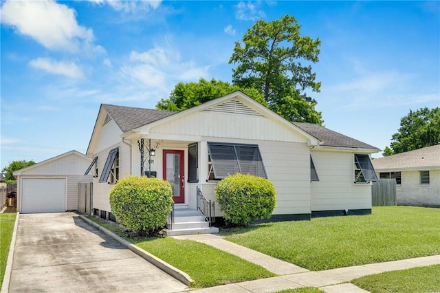 401 Riverdale Dr, Jefferson, LA 70121 - view of front facade featuring concrete driveway, an outdoor structure, a garage, a front lawn, and roof with shingles