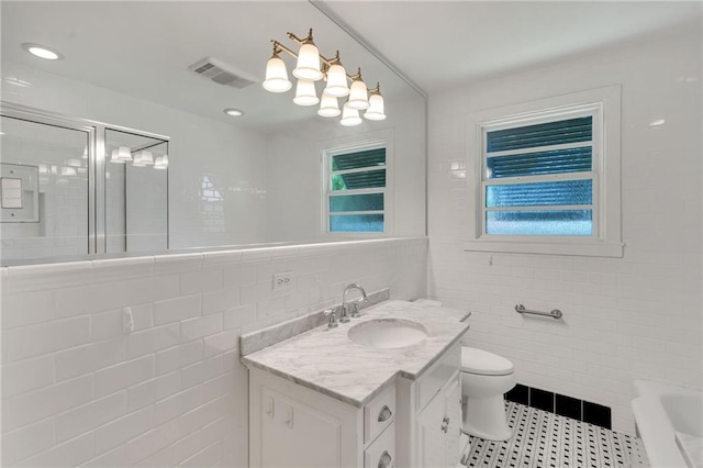 401 Riverdale Dr, Jefferson, LA 70121 - full bath featuring tile walls, a shower with door, vanity, toilet, and a bath