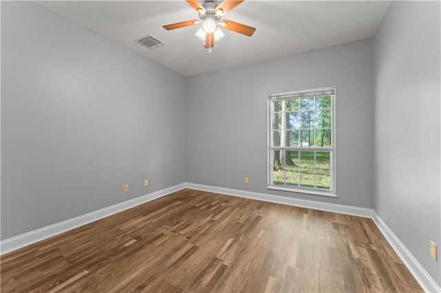 empty room featuring wood finished floors, baseboards, and ceiling fan