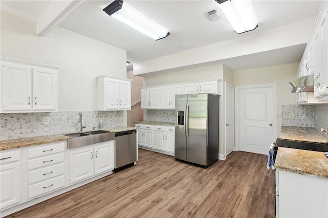 436 Nighthawk Dr, Slidell, LA 70461 - kitchen with stainless steel appliances, white cabinetry, tasteful backsplash, wall chimney exhaust hood, and light wood-type flooring