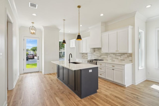 342 W Ave, Harahan, LA 70123 - kitchen with a sink, white cabinetry, light countertops, tasteful backsplash, and light wood-style flooring