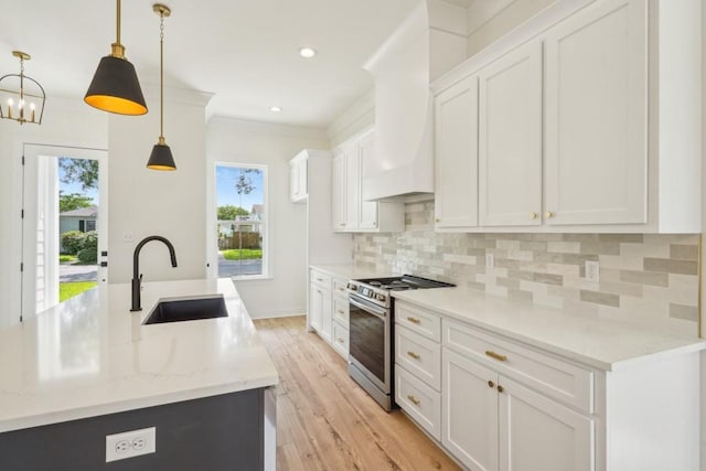 342 W Ave, Harahan, LA 70123 - kitchen featuring gas stove, a sink, tasteful backsplash, white cabinets, and light wood-style flooring