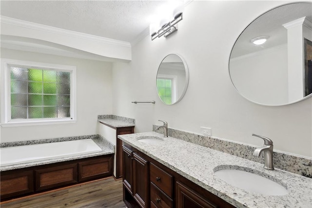 25512 W Spruce St, Lacombe, LA 70445 - bathroom with plenty of natural light, ornamental molding, double vanity, a textured ceiling, and wood finished floors