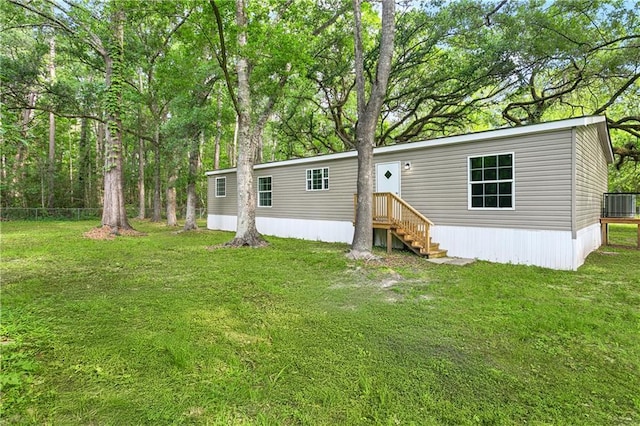25512 W Spruce St, Lacombe, LA 70445 - rear view of property featuring central AC unit and a yard