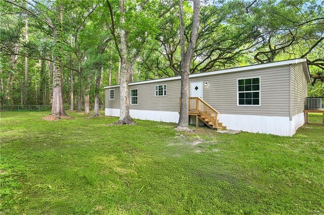 25512 W Spruce St, Lacombe, LA 70445 - rear view of property featuring central AC unit and a yard