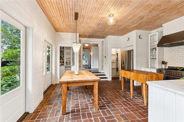 1612 Milan St, New Orleans, LA 70115 - dining room featuring brick floors, wood ceiling, a chandelier, and wooden walls