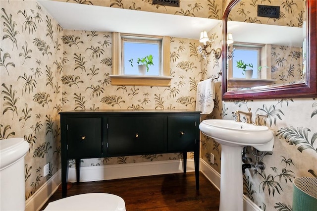 1612 Milan St, New Orleans, LA 70115 - bathroom with toilet, wallpapered walls, wood finished floors, healthy amount of natural light, and a sink