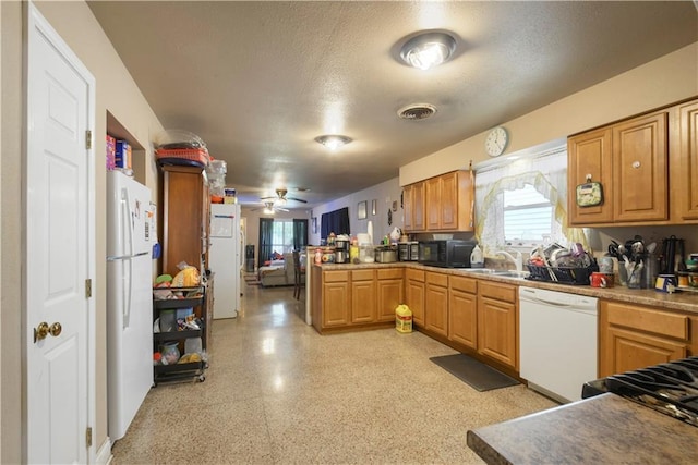 521 S Alexander St, New Orleans, LA 70119 - kitchen featuring white appliances, healthy amount of natural light, a peninsula, a textured ceiling, and a sink