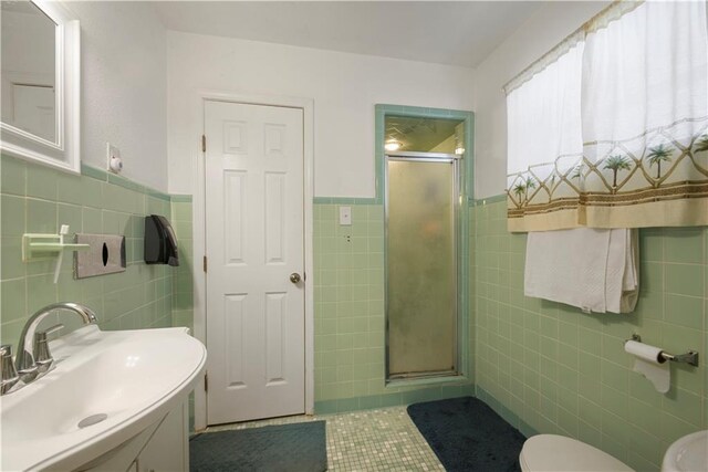 521 S Alexander St, New Orleans, LA 70119 - full bathroom with tile walls, a stall shower, tile patterned flooring, toilet, and wainscoting