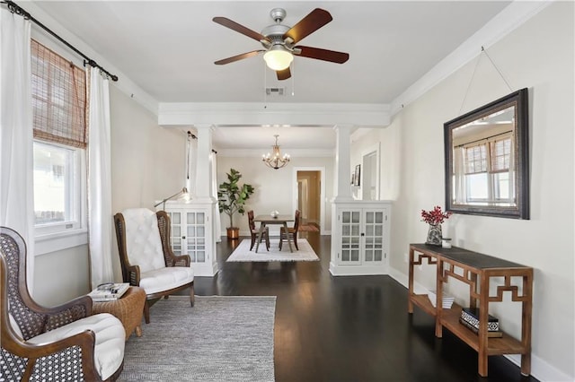 7715 Panola St, New Orleans, LA 70118 - living area with decorative columns, dark wood finished floors, healthy amount of natural light, and crown molding