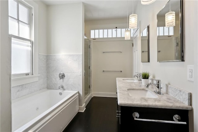 7715 Panola St, New Orleans, LA 70118 - bathroom featuring a bath, double vanity, a stall shower, baseboards, and wood finished floors