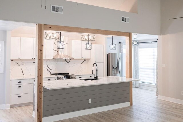 114WCHAMALECOVE W Chamale Cv, Slidell, LA 70460 - kitchen featuring a sink, appliances with stainless steel finishes, white cabinetry, light wood finished floors, and light stone countertops