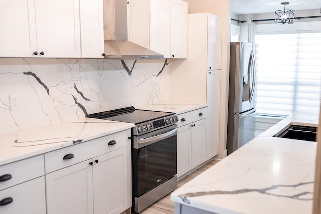 114WCHAMALECOVE W Chamale Cv, Slidell, LA 70460 - kitchen with appliances with stainless steel finishes, wall chimney range hood, light wood finished floors, and white cabinetry