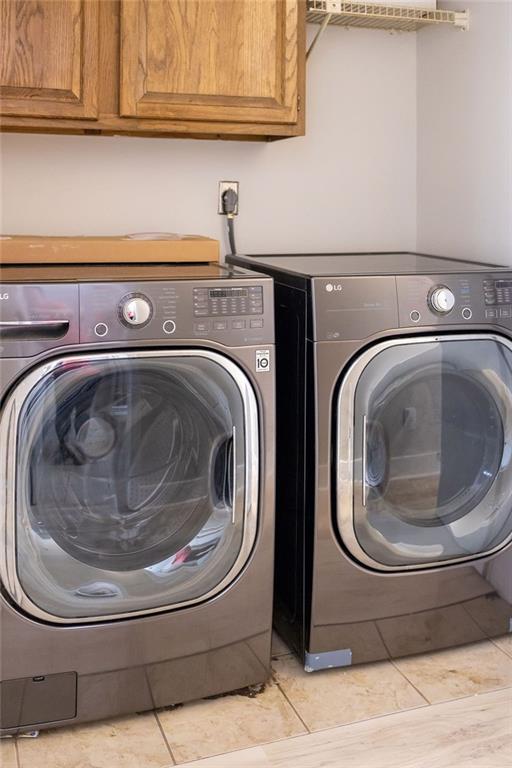 114WCHAMALECOVE W Chamale Cv, Slidell, LA 70460 - clothes washing area with cabinet space, separate washer and dryer, and light tile patterned floors