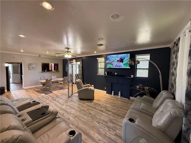 2820 Annette St, New Orleans, LA 70119 - living room featuring crown molding, baseboards, a ceiling fan, healthy amount of natural light, and light wood-type flooring
