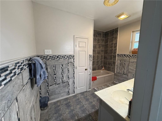 2820 Annette St, New Orleans, LA 70119 - full bath featuring tile walls, a bath, vanity, wainscoting, and tile patterned floors