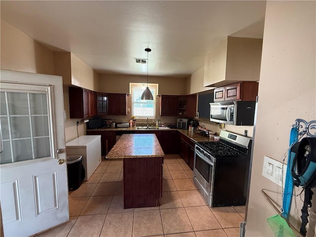 2820 Annette St, New Orleans, LA 70119 - kitchen featuring stainless steel appliances, a center island, pendant lighting, glass insert cabinets, and a sink