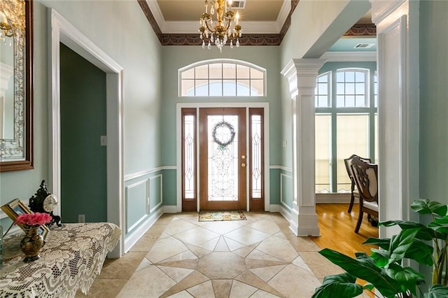 10 Harbor Cv, Slidell, LA 70458 - foyer entrance featuring ornamental molding, a chandelier, ornate columns, light tile patterned flooring, and baseboards