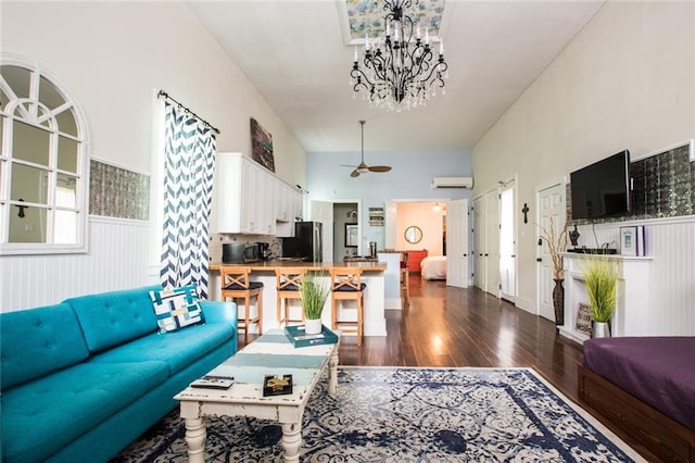 1241 Kerlerec St, New Orleans, LA 70116 - living area with wood finished floors, a wainscoted wall, a wall mounted air conditioner, a chandelier, and ceiling fan