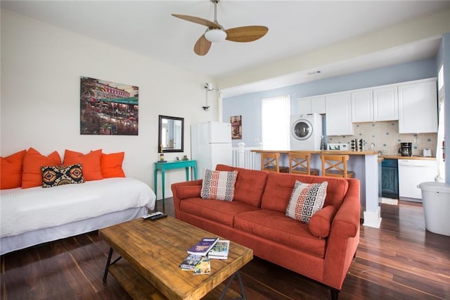1241 Kerlerec St, New Orleans, LA 70116 - living room with stacked washer / dryer, ceiling fan, and dark wood finished floors