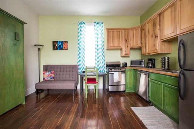 1241 Kerlerec St, New Orleans, LA 70116 - kitchen featuring appliances with stainless steel finishes, green cabinets, and dark wood-style floors