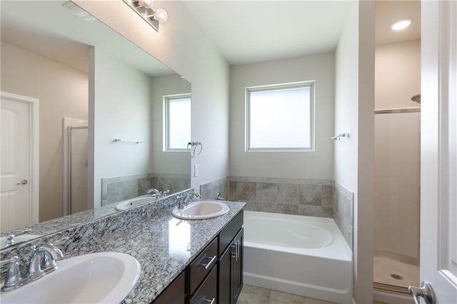bathroom with a shower stall, a bath, and double vanity