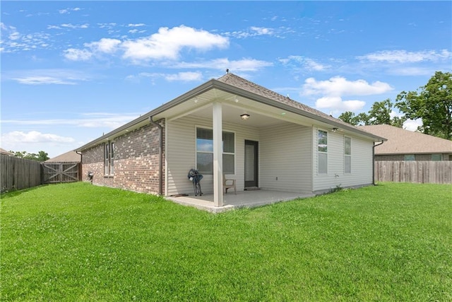 back of house with a patio and brick siding