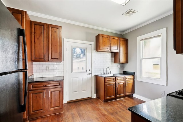 316 Milling Ave, Luling, LA 70070 - kitchen featuring freestanding refrigerator, a sink, dark wood finished floors, backsplash, and crown molding