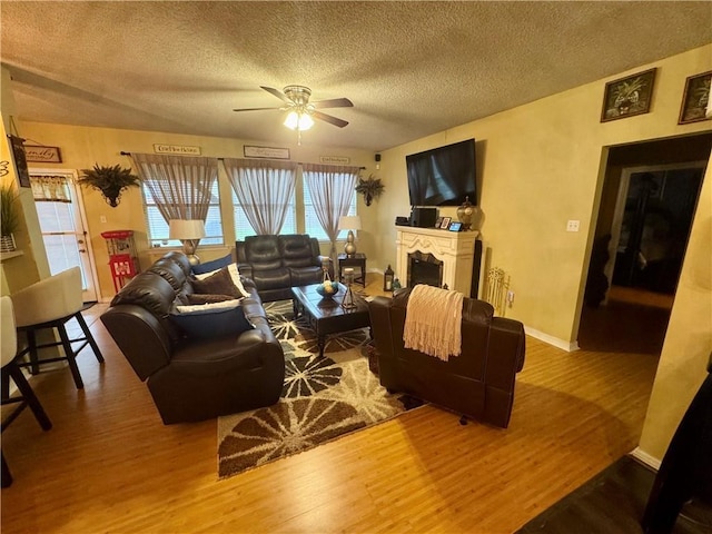 2132 Wellington Ln, Slidell, LA 70461 - living area featuring a fireplace, wood finished floors, a ceiling fan, and a textured ceiling
