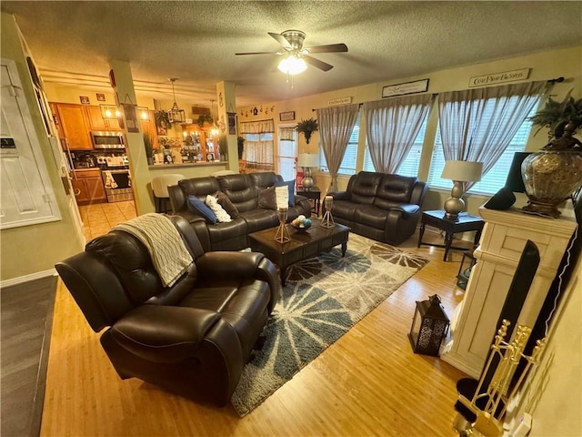 2132 Wellington Ln, Slidell, LA 70461 - living room featuring ceiling fan, wood finished floors, a textured ceiling, and baseboards